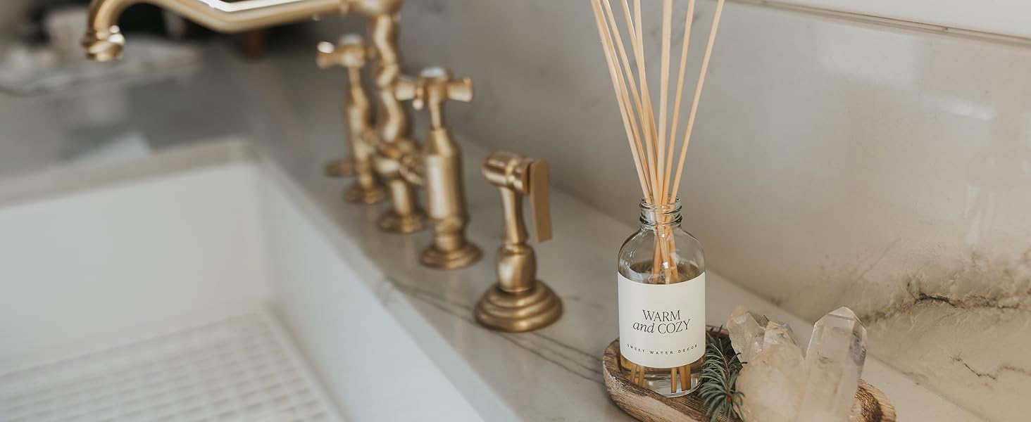 Warm and Cozy Reed Diffuser sitting on a counter in a wood tray.