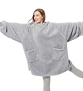 Oversized gray wearable blanket with sleeves and front pockets. Person wearing it with arms outstretched, demonstrating its size and comfort.