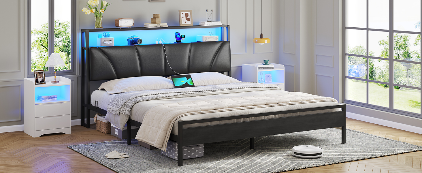 Modernes Bettgestell mit schwarz gepolstertem Kopfteil, integrierter LED-Beleuchtung und Seitenablagen. Es verfügt über weiße Nachttische und wird in einem hellen Schlafzimmer präsentiert