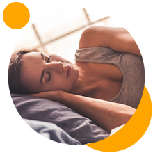 Personne allongée sur une surface, les bras levés au-dessus de la tête, avec des éléments circulaires oranges en arrière-plan