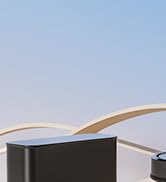 Architektonisches Außendetail, das den Rand oder die Ecke einer modernen Gebäudestruktur vor einem hellblauen Himmel zeigt.