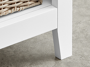 Egy fehér bútordarab, esetleg asztal vagy polc sarka beton- vagy szürke padlófelületen.