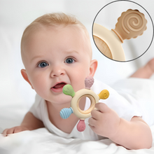 Baby teething toy with wooden ring handle. Close-up shows textured surface. Infant demonstrating use by chewing on the toy.