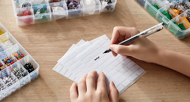 Die Hände einer Person, die einen Stift hält und auf ein Blatt Papier schreibt.