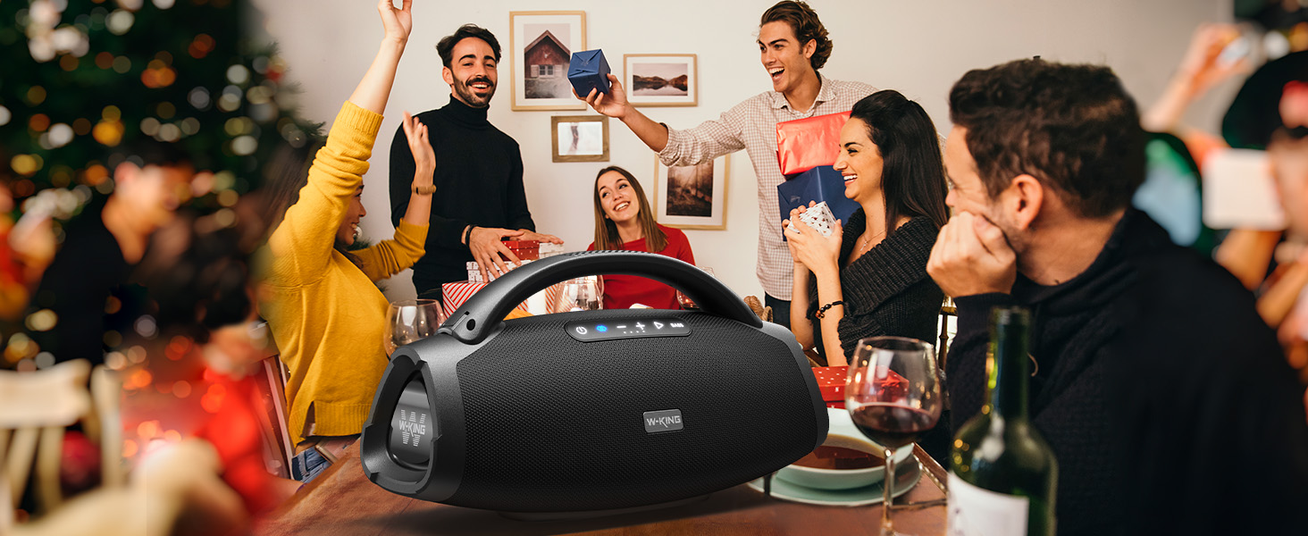 a group of people around a table with a bluetooth speaker.