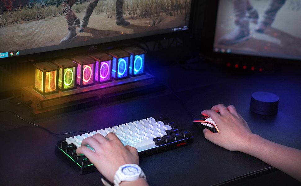 Gaming-Setup mit beleuchteter RGB-Tastatur und -Maus auf dunklem Schreibtisch, mit farbenfrohem LED-Display mit Zahlen im Hintergrund.