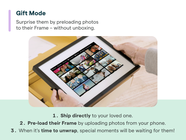 Skylight digital photo frame on table, with hand holding phone.