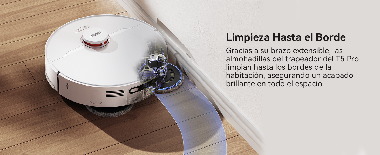con brazo extensible que limpia a lo largo de zócalos sobre suelo de madera. El dispositivo tiene una tapa blanca, un compartimento para el polvo transparente y un mecanismo de cepillo visible