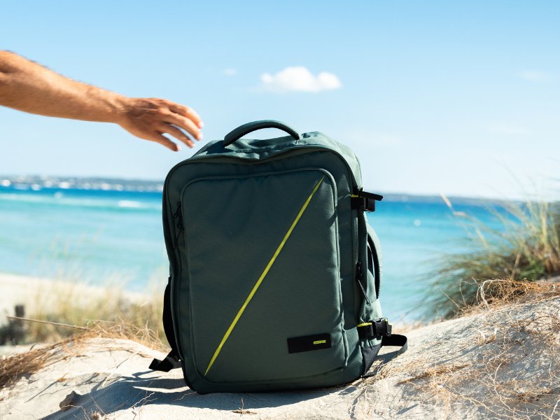 Outdoor beach scenes featuring black camera equipment or gear positioned on rocky coastal terrain with ocean in background.