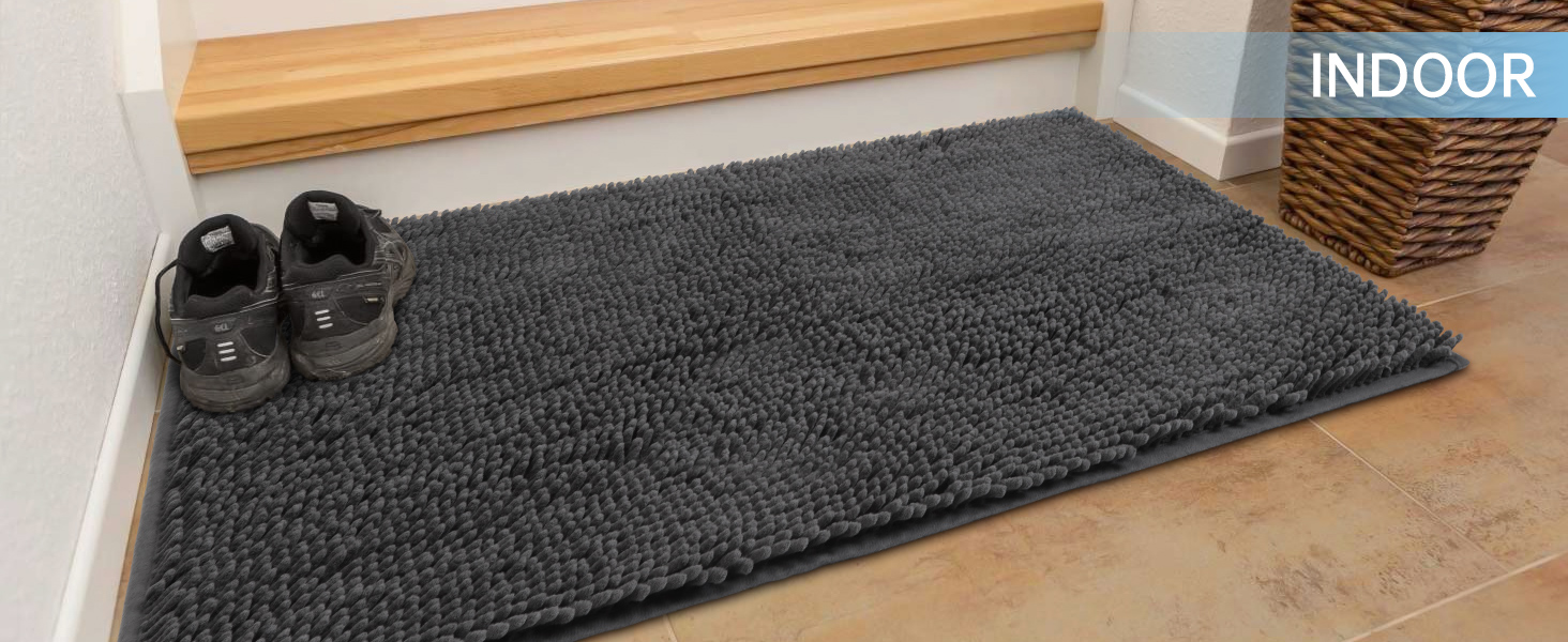 A chenille doormat placed beside the indoor staircase, and a pair of shoes is also put on it.