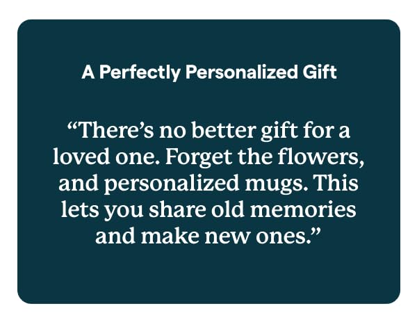 Skylight digital photo frame on table, with hand holding phone.