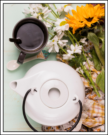 Assiette ou plat de service circulaire blanc avec échancrure centrale, présenté à côté de céramiques foncées et de fleurs fraîches sur une surface claire