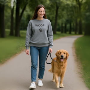 Person wearing dog-themed sweatshirt holding their pet