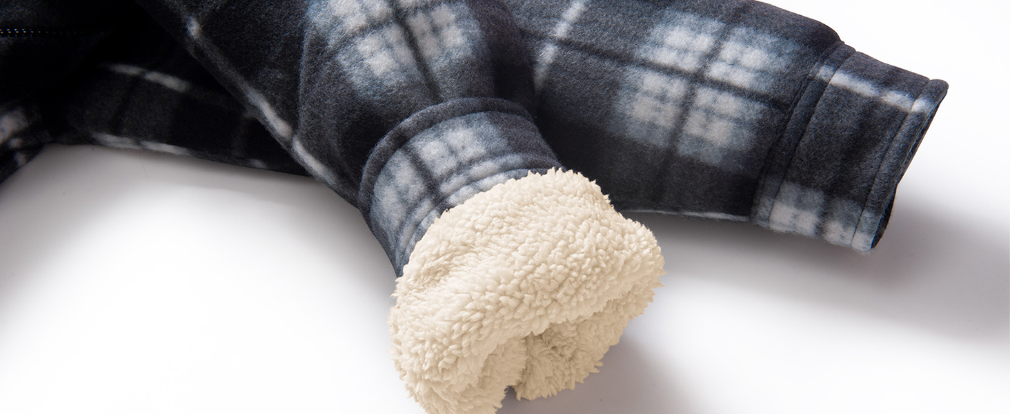 Nahaufnahme eines karierten Stoffärmels mit einem flauschigen weißen Sherpafutter, das an der Manschette sichtbar ist und an ein warmes Winterkleid erinnert