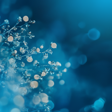 Fond bleu abstrait avec des formes circulaires blanches ressemblant à des bulles ou à des lumières bokeh, créant une atmosphère aquatique de rêve