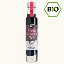 Auf dem Text steht „BIO“ in einem grünen sechseckigen Logo. Dunkle Glasflasche mit rotem Verschluss, die Flüssigkeit enthält, scheint ein biologisch zertifiziertes Produkt zu sein.