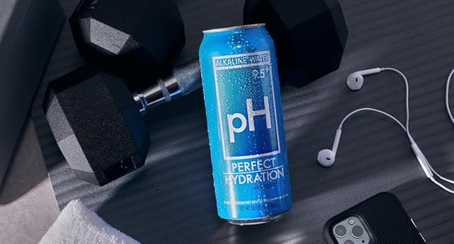 perfect hydration alkaline water can in a workout flatlay with weights, headphones and a smart phone