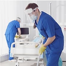 Masked medical professional cleaning a hospital room