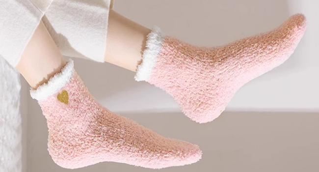 Multiple views of plush, cozy socks in light pink color with white trim, shown from different angles laying flat on a light gray surface.