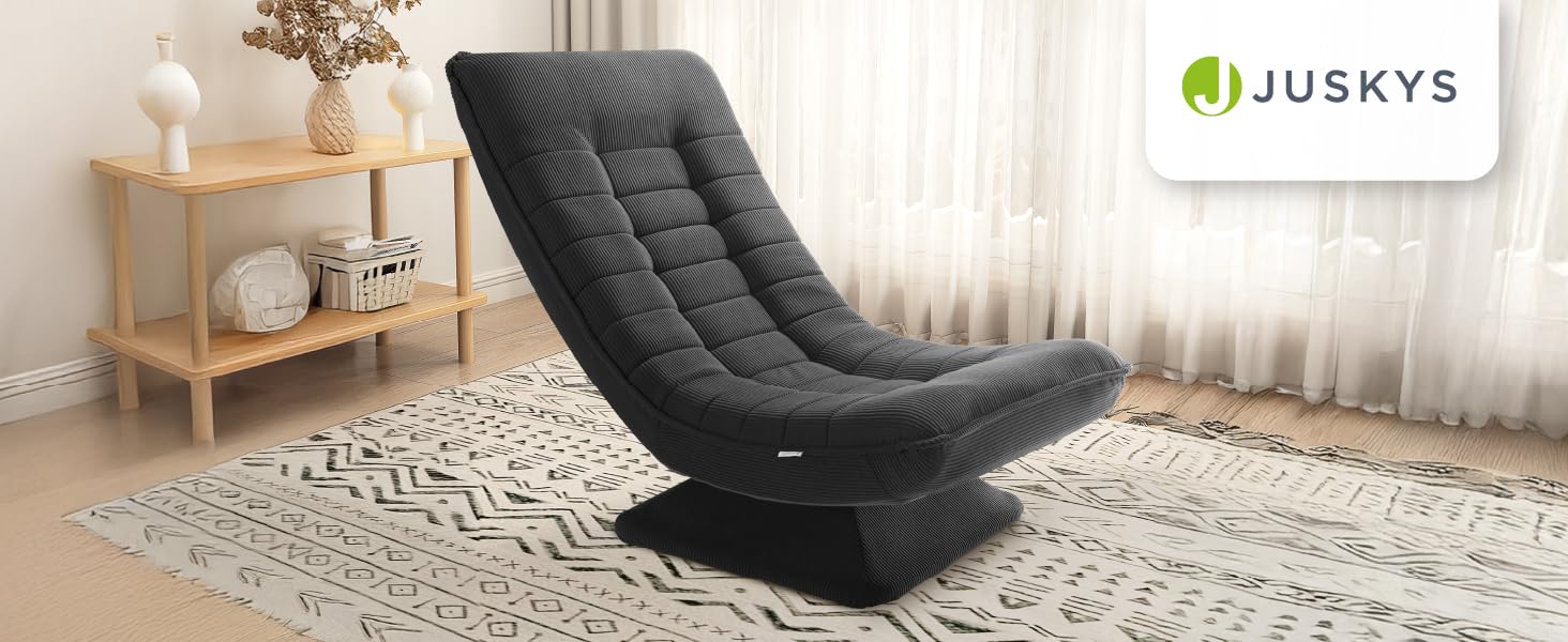 Geschwungener Schaukelstuhl mit weicher grauer Polsterung und getufteter Polsterung. Auf einem gemusterten Teppich in einem Wohnzimmer mit Beistelltisch aus Holz platziert.