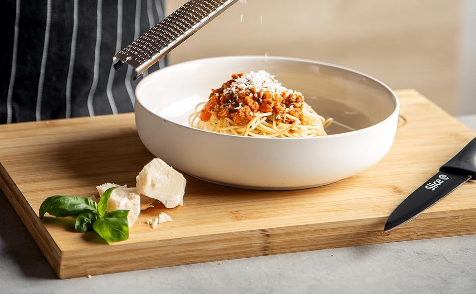 Chopping board being used as serving tray for spaghetti