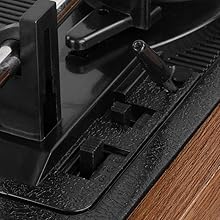 Close-up of black electronic device components on wooden surface, showing technical internal mechanisms and connections.