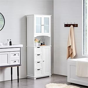 White bathroom storage cabinet with glass door and multiple drawers. Placed in a bright bathroom setting next to a wall-mounted coat rack.
