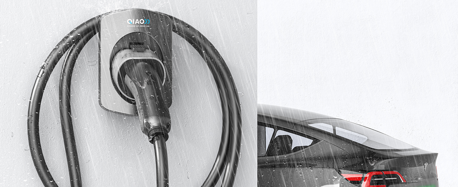 Coiled black cable or charging cord mounted on a wall, with partial view of equipment in background.