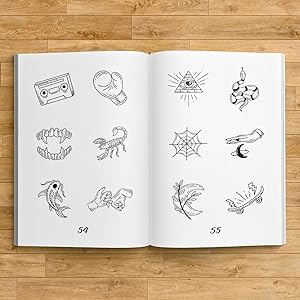 An open tattoo design book showing a koi fish, a cassette tape, a skateboard, a scorpion and a snake