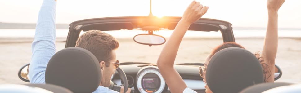 a couple in the car raising their hands as they are enjoying the ride