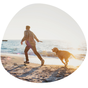 Man and Healthy Dog Running and Playing on the Beach
