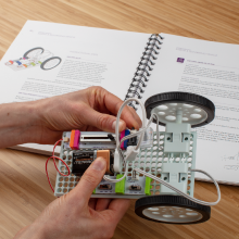 Talimat kılavuzunun yanında buluş yapan eller.