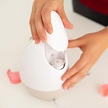 Vrouwen vullen de watertank in de Microderm Glow Facial Steamer