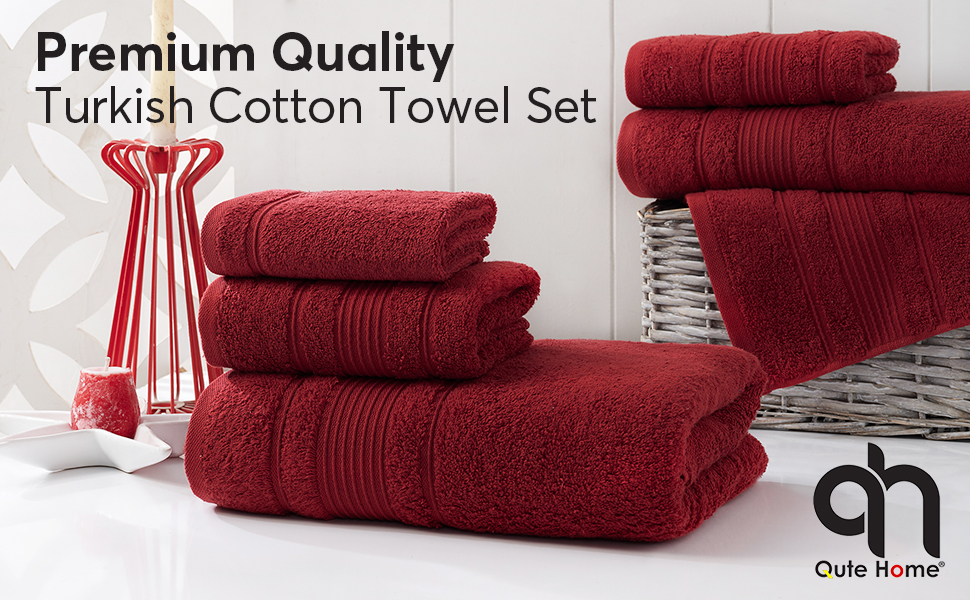 Burgundy bath towels, hand towels and washcloths on counter in bathroom