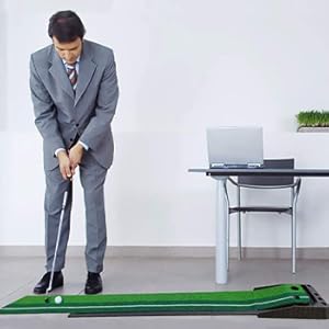 a man is playing putting mat in his office