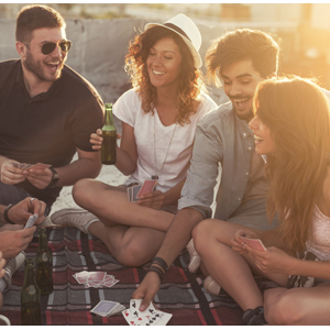 Games with friends outside card games people laughing sun setting in background