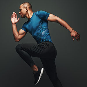 Athlete running on dark background