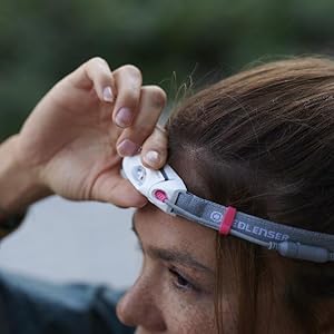 Läuferin mit Stirnlampe schaltet Lampe ein