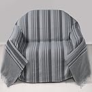 Grauer Überwurf auf dem Sofa.