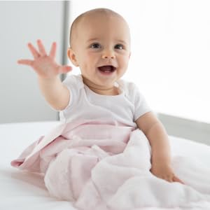 Baby wrapped in Little Giraffe Luxe Baby Blanket in pink.