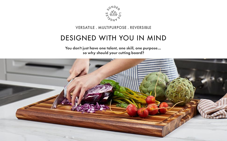 Person cutting beautiful fresh produce on a large teak wood cutting board.