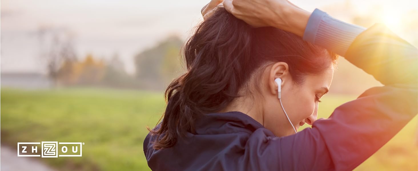 Healthy young woman tying back her long well nourished hair before her morning jog.