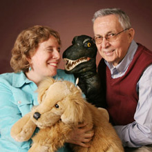 Founders Judy and Atis Folkmanis smiling and holding puppets.