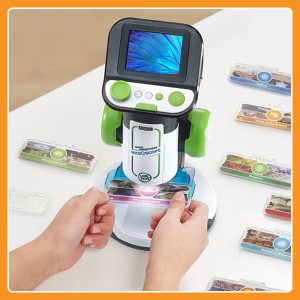 View of microscope screen and kid's hands holding slide.