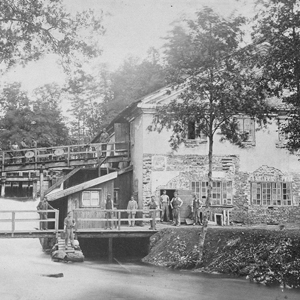 People near a house by a river