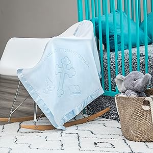 Blue baptism blanket in nursery on rocking chair next to crib