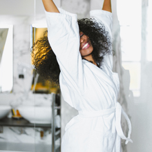 Woman in bath robe preparing argan bath oil soak 