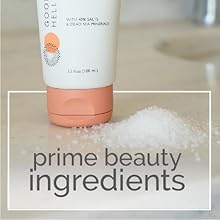 Bottom half of face wash bottle on bathroom counter next to a small pile of salt on stone counter