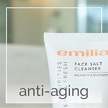 Top left corner of face wash with bathroom counter, sink, backsplash, and mirror in background