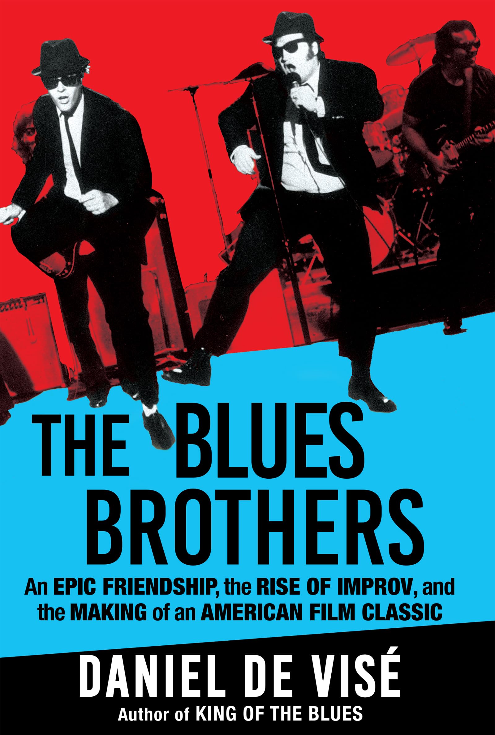 Book cover for The Blues Brothers by Daniel de Visé. The top half shows a red background with black-and-white images of the Blues Brothers—two men in suits, hats, and sunglasses—performing on stage. The bottom half features a bright blue background with the title in large black text. Subtext reads: "An epic friendship, the rise of improv, and the making of an American film classic." At the bottom, the author's name and "Author of King of the Blues" appear in white text on black.